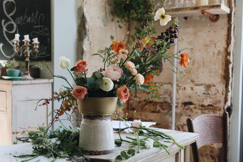 Beautiful arrangement of flowers in a rustic workshop setting, capturing nature's elegance.
